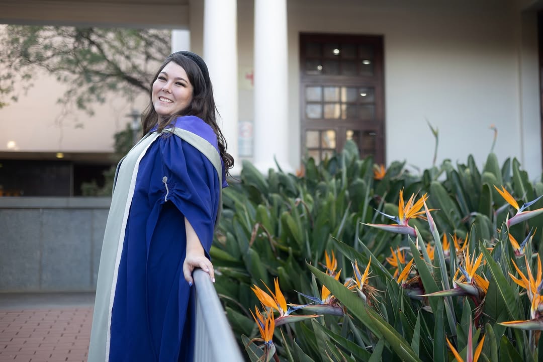 Graduate portrait with school crest in background